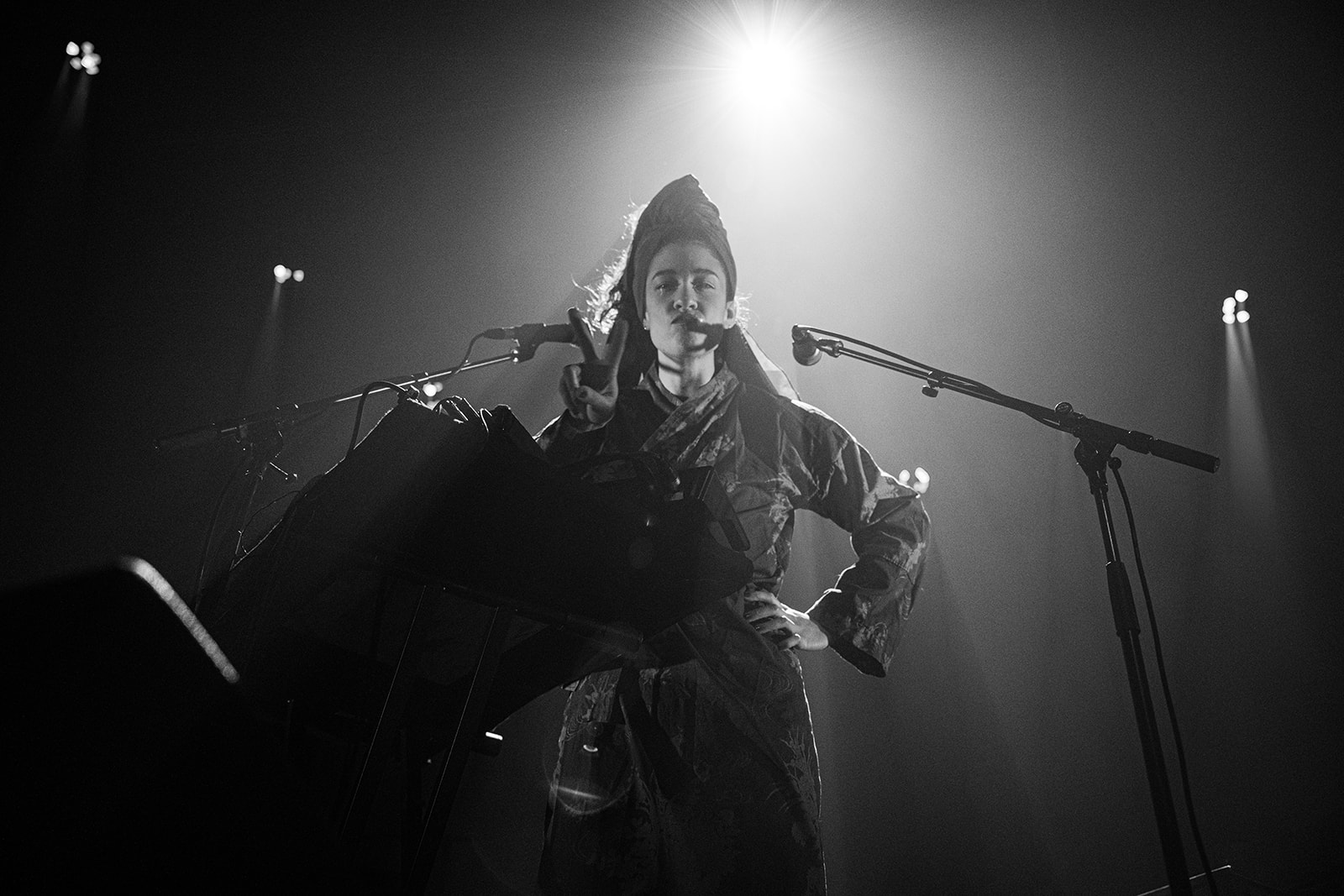 Artiste sur scène dans un halo de lumière agressive
